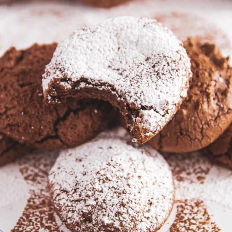 A rich, fudgy cookie with a bite taken out, showing its soft interior.